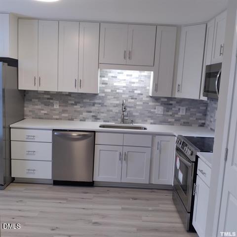 1015 Holmes Street Raleigh, NC 27601 - Photo 4 of 12 a kitchen with white cabinets stainless steel appliances and sink
