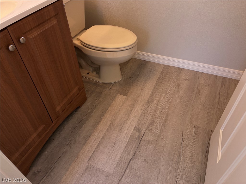 10 Caprington Road Henderson, NV 89052 - Photo 33 of 44 Clean lines and a wood-look vinyl floor create a functional, modern bathroom space.