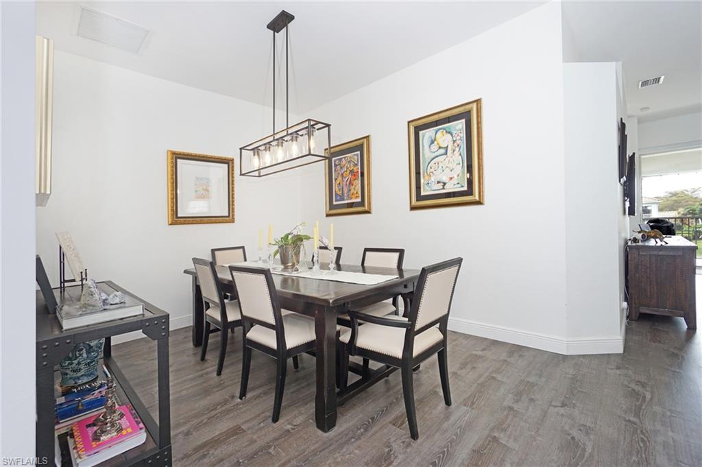 6910 Satinleaf Road North, Unit 204 Naples, FL 34109 - Photo 12 of 31 Dining area featuring wood finished floors, baseboards, and visible vents