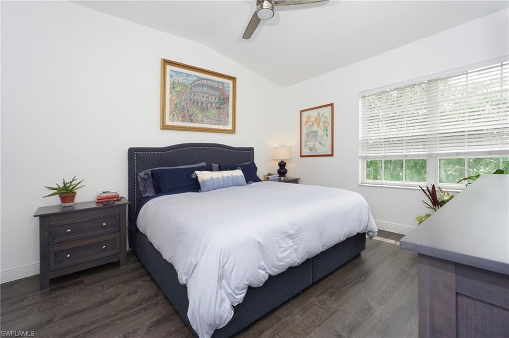 6910 Satinleaf Road North, Unit 204 Naples, FL 34109 - Photo 16 of 31 Bedroom featuring baseboards, lofted ceiling, dark wood-type flooring, and a ceiling fan