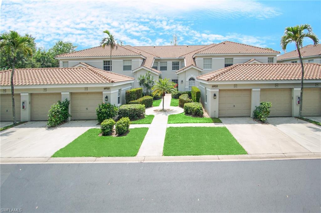 6910 Satinleaf Road North, Unit 204 Naples, FL 34109 - Photo 2 of 31 View of front facade featuring a tiled roof, concrete driveway, and stucco siding