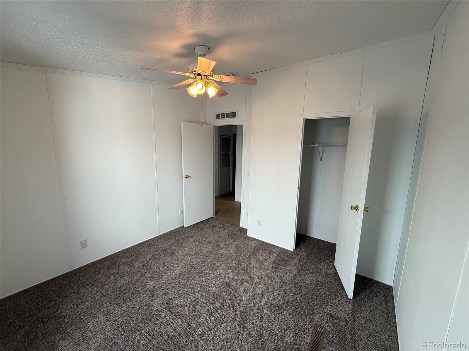 623 Prairie Avenue Brighton, CO 80603 - Photo 11 of 35 an empty room with a mirror and a ceiling fan