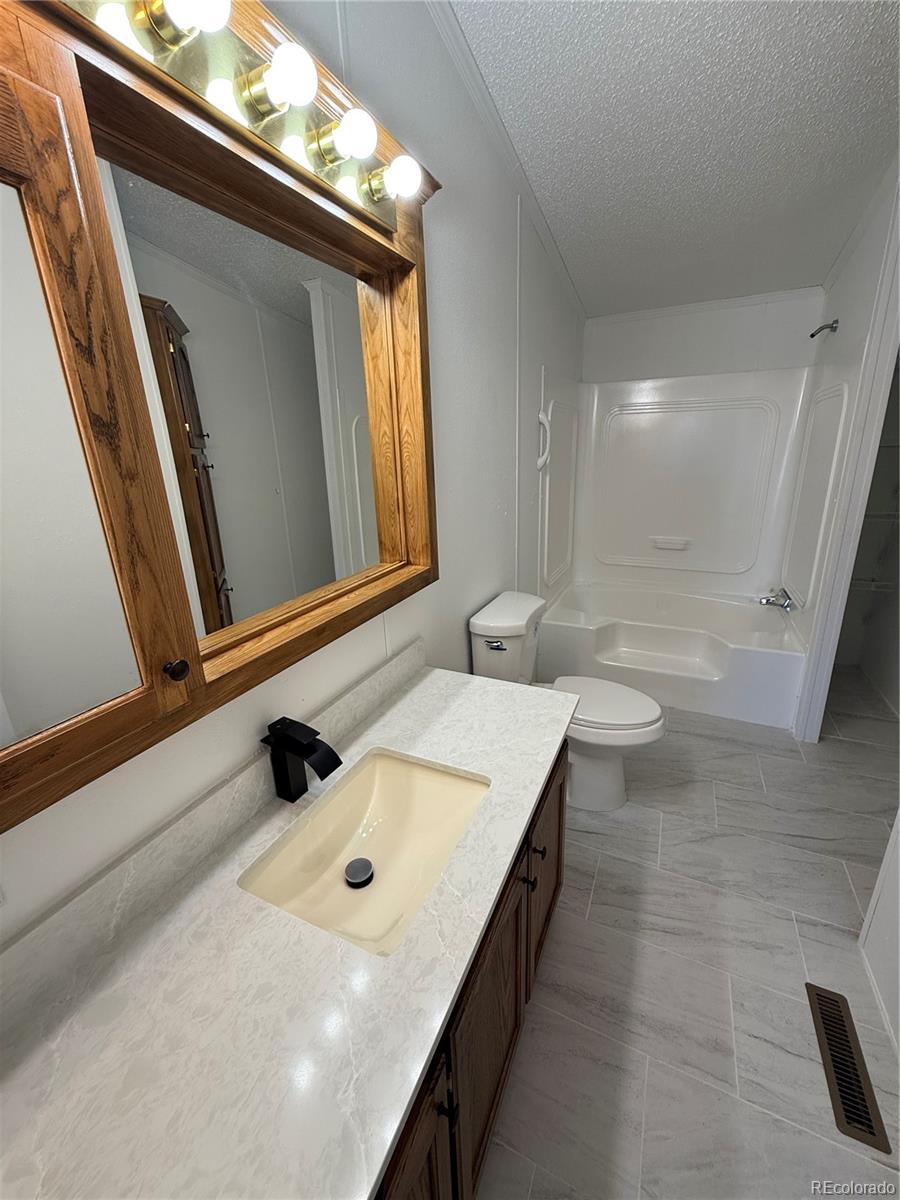 623 Prairie Avenue Brighton, CO 80603 - Photo 14 of 35 a bathroom with a sink a toilet and mirror