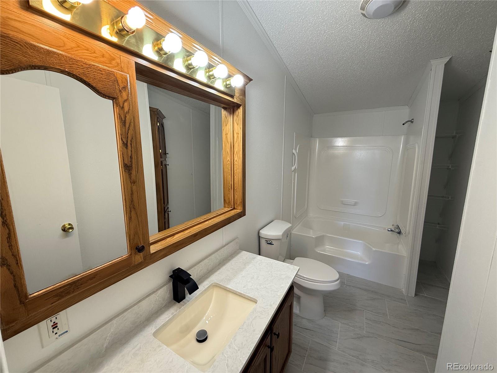 623 Prairie Avenue Brighton, CO 80603 - Photo 17 of 35 a bathroom with a sink a toilet and shower