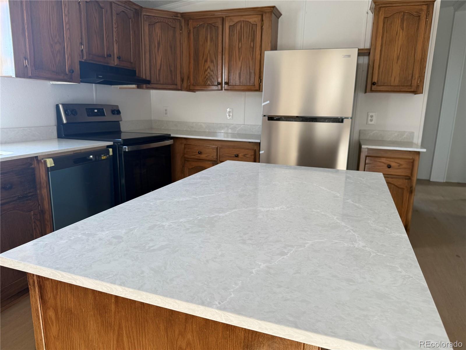 623 Prairie Avenue Brighton, CO 80603 - Photo 28 of 35 a kitchen with kitchen island a refrigerator sink and cabinets