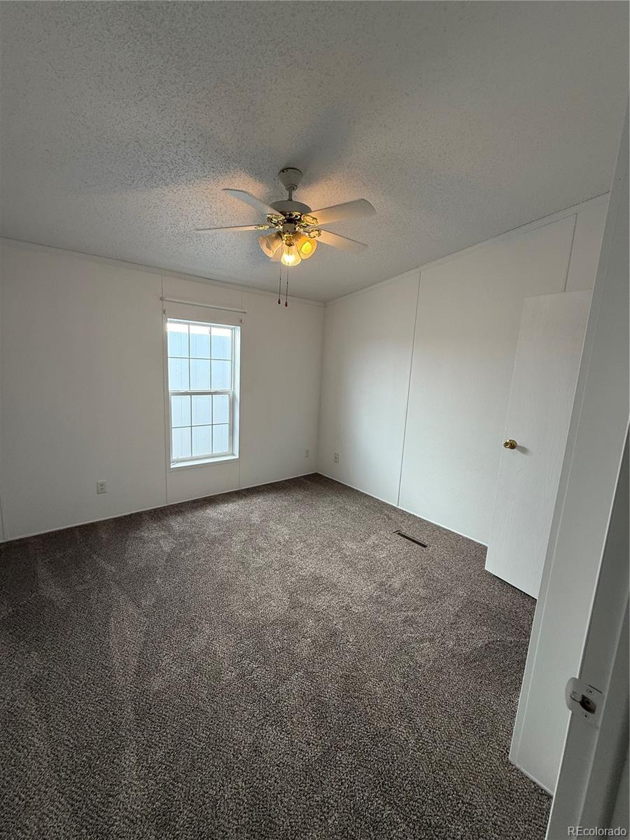 623 Prairie Avenue Brighton, CO 80603 - Photo 7 of 35 an empty room with windows and chandelier fan