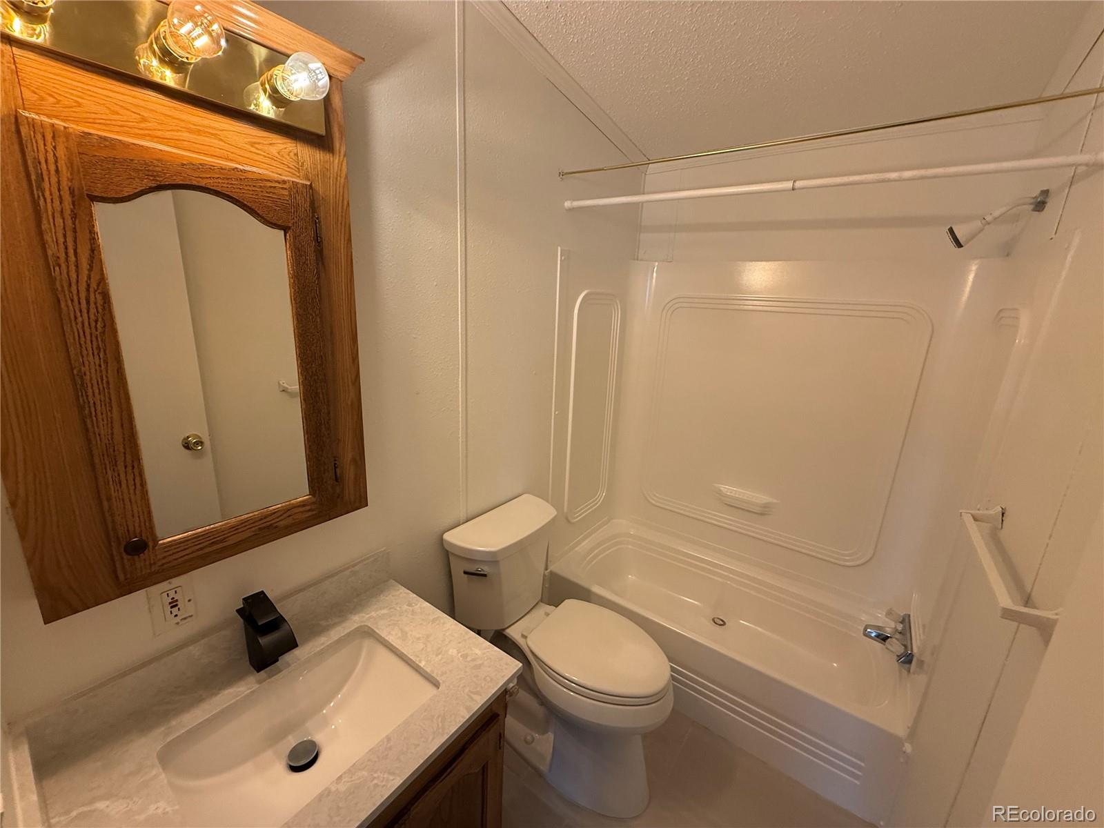 623 Prairie Avenue Brighton, CO 80603 - Photo 10 of 35 a bathroom with a sink a toilet and shower