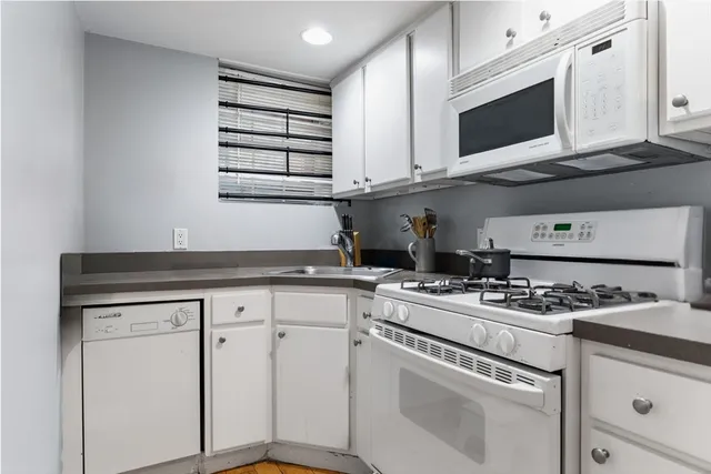 a kitchen with cabinets appliances a sink and a counter