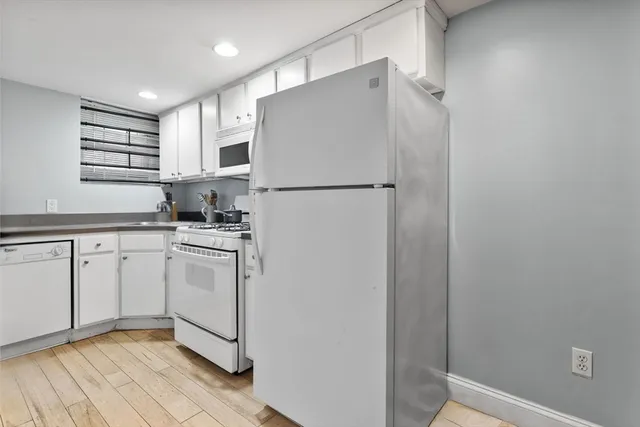 a kitchen with white cabinets and white appliances
