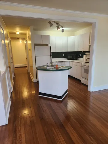 a view of kitchen with cabinets and wooden floor