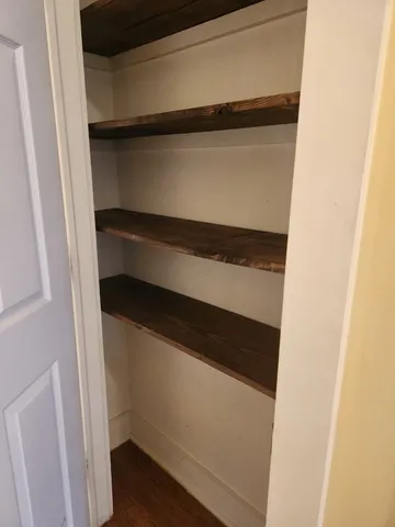 a view of walk in closet with empty racks