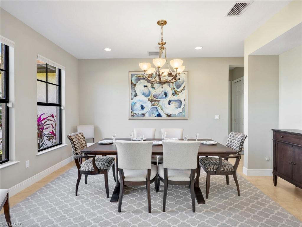 3160 27th Avenue Southwest Naples, FL 34117 - Photo 16 of 43 a view of a dining room with furniture wooden floor and a chandelier