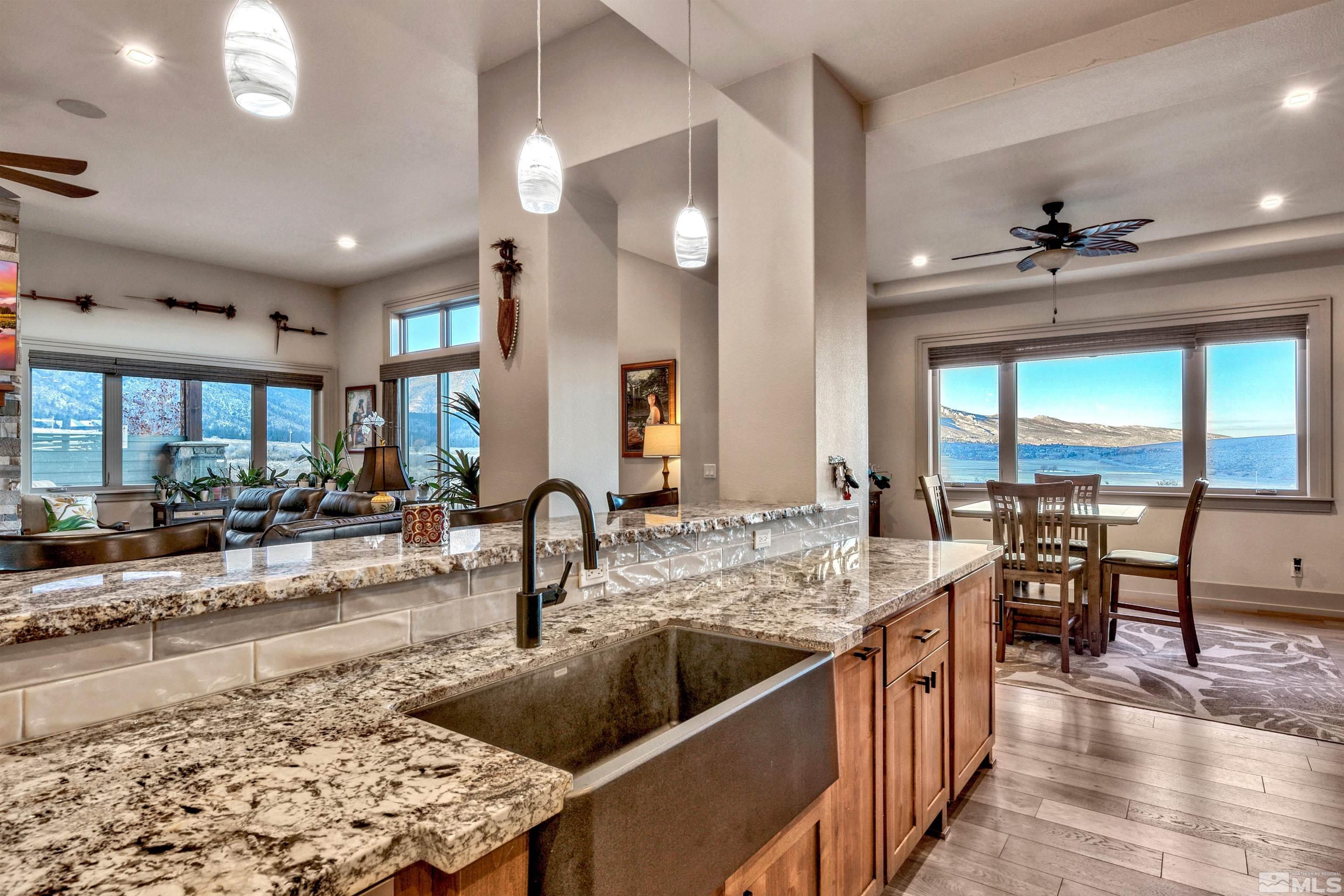 316 James Canyon Loop Genoa, NV 89411 - Photo 14 of 40 a kitchen with a stove a sink a dining table and chairs with wooden floor