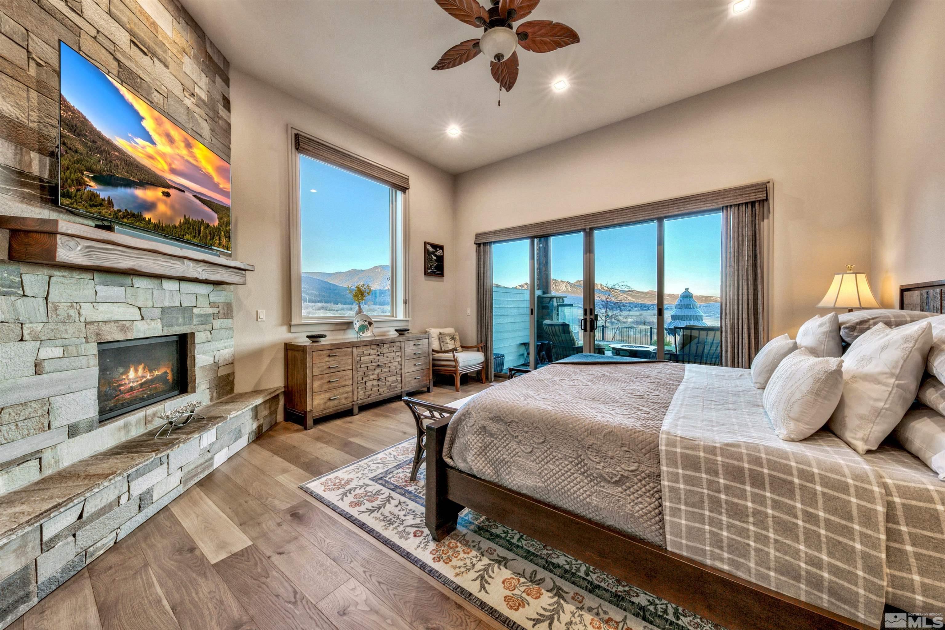 316 James Canyon Loop Genoa, NV 89411 - Photo 16 of 40 a bedroom with a large bed and a fireplace