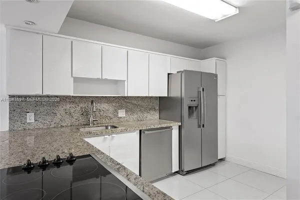 a kitchen with stainless steel appliances granite countertop a refrigerator and a stove