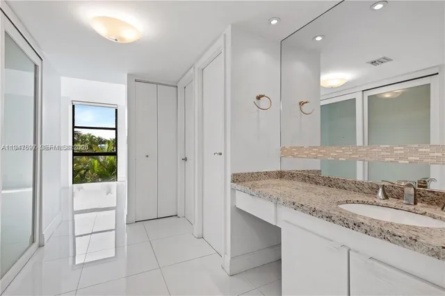 a bathroom with a granite countertop sink and a mirror