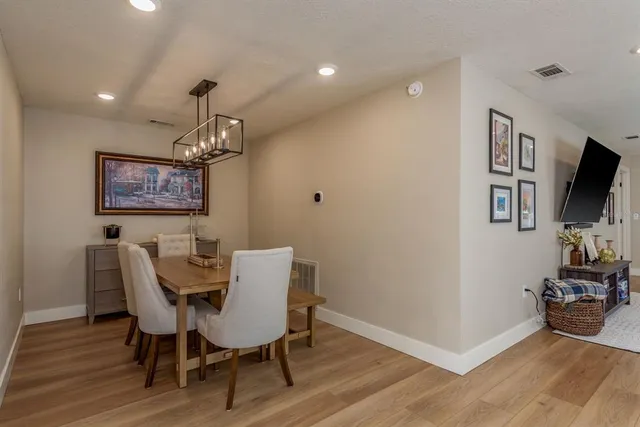 a view of a dining room with furniture wooden floor and a chandelier