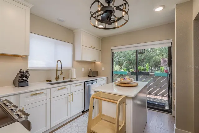 a kitchen with a stove a sink and cabinets