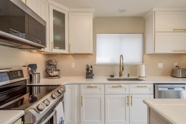 a kitchen with stainless steel appliances granite countertop a sink stove and cabinets