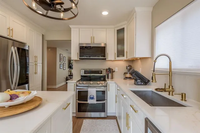 a kitchen with stainless steel appliances a sink stove and refrigerator