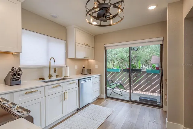 a kitchen that has a lot of cabinets and wooden floor