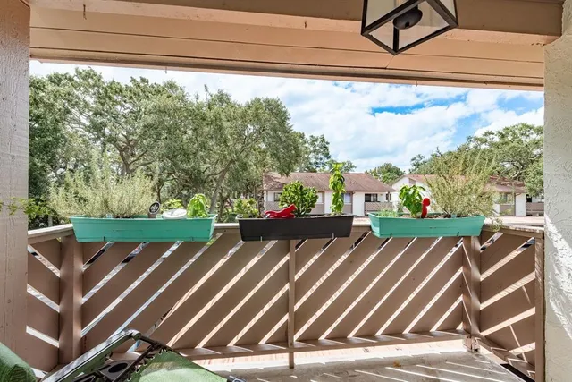 a view of a tennis room with wooden floor and fence