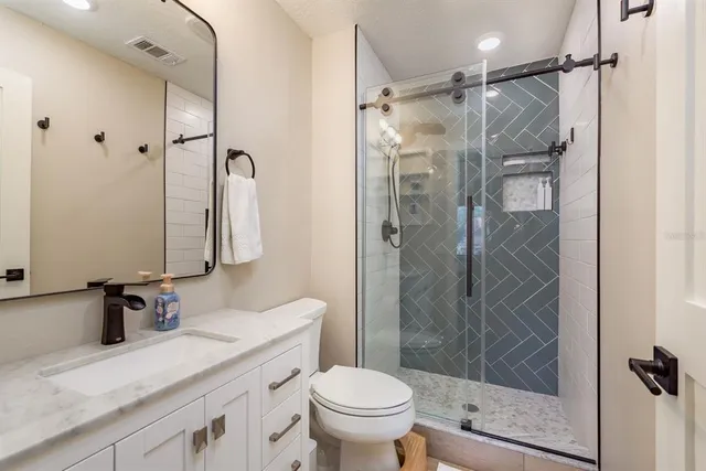 a bathroom with a granite countertop sink toilet and shower