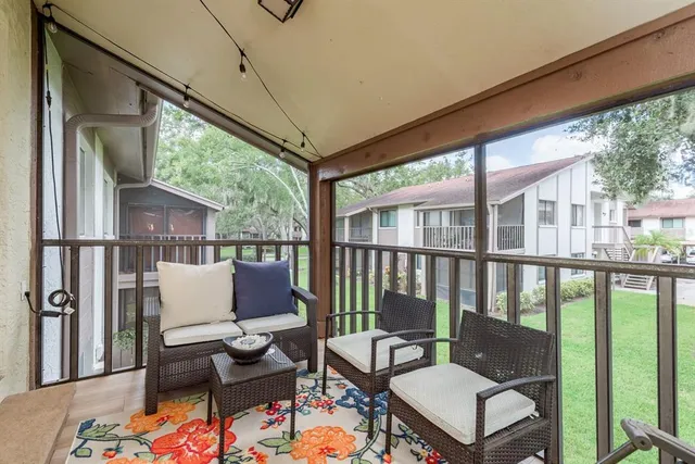 a balcony with wooden floor and outdoor seating