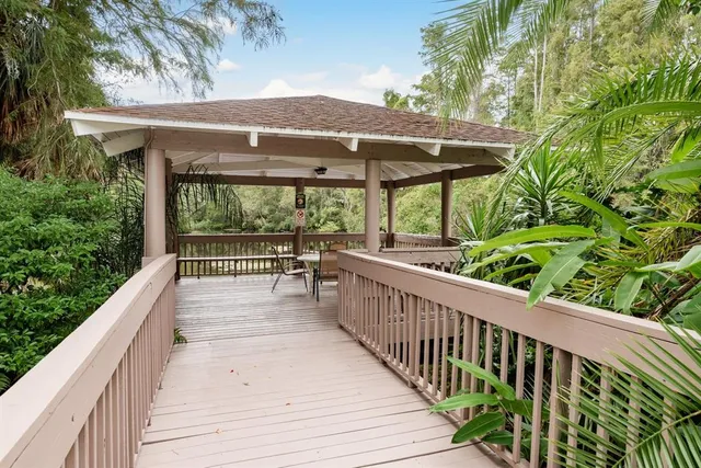 a view of a patio with table and chairs under an umbrella with a small yard