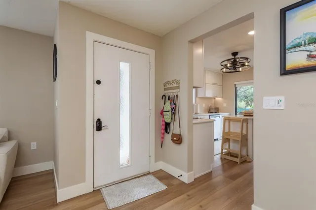 a view of a hallway with wooden floor and a bathroom