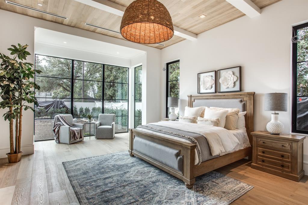 4306 Gloster Road Dallas, TX 75220 - Photo 16 of 28 a bedroom with a large bed and a chandelier