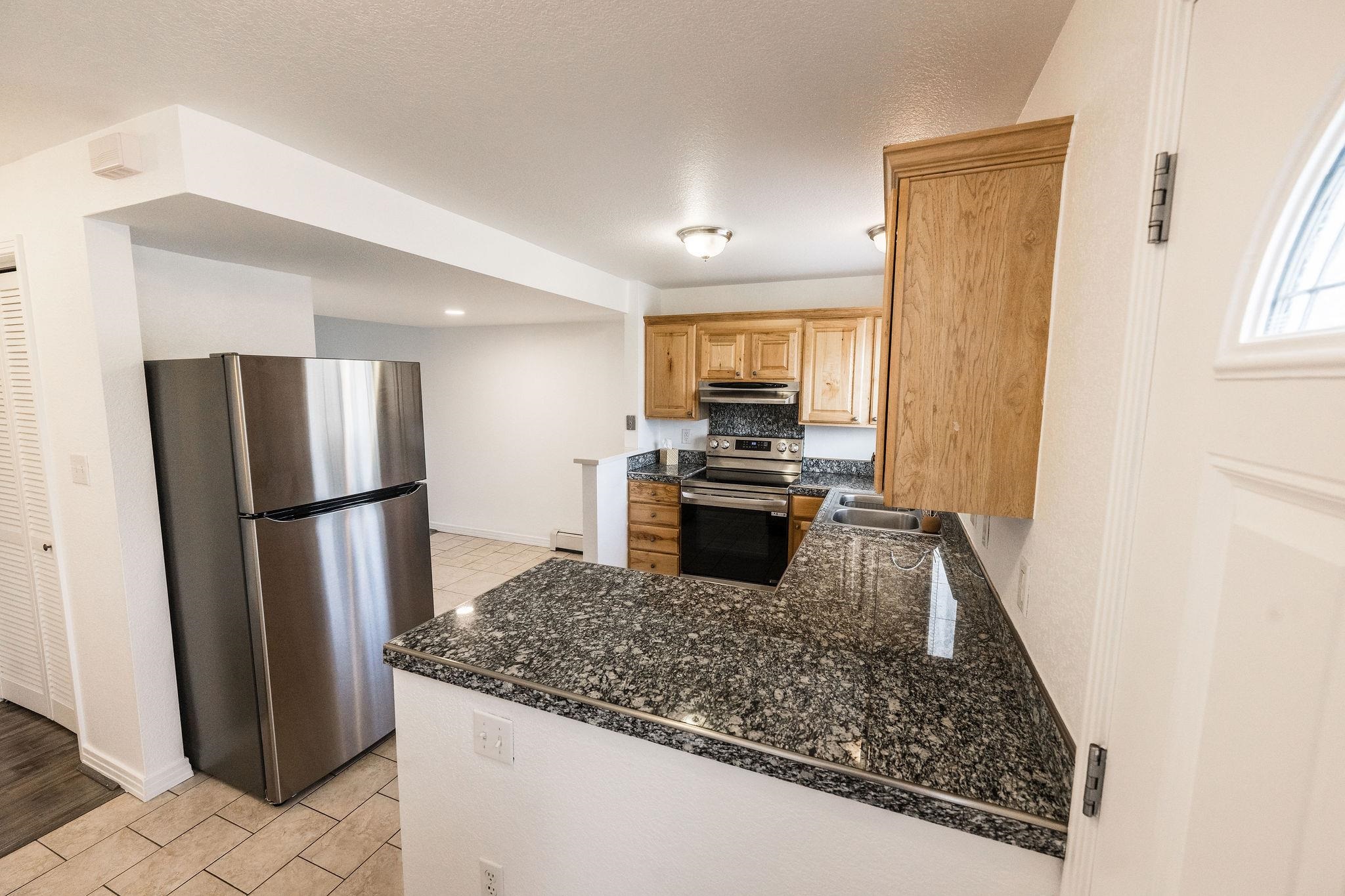 2721 Patterson Road, Unit 104 Grand Junction, CO 81506 - Photo 3 of 20 a kitchen with stainless steel appliances granite countertop a refrigerator a stove and a sink