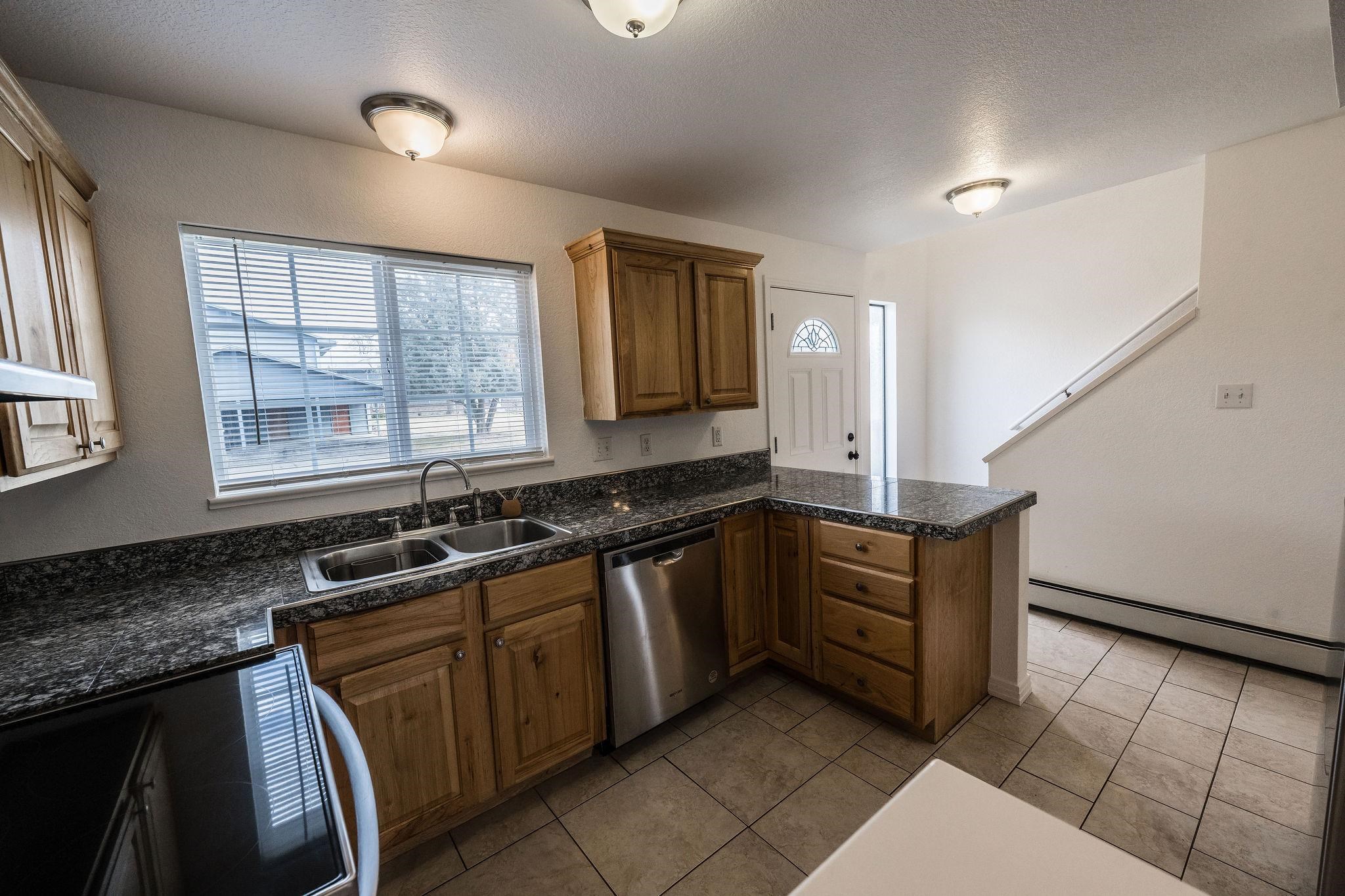 2721 Patterson Road, Unit 104 Grand Junction, CO 81506 - Photo 4 of 20 a kitchen with granite countertop a sink stove and cabinets