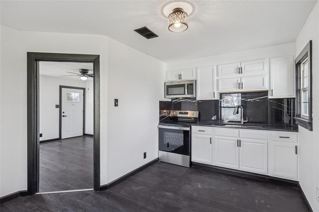 4816 Foard Street Fort Worth, TX 76119 - Photo 13 of 25 a kitchen with stainless steel appliances a stove sink microwave and cabinets
