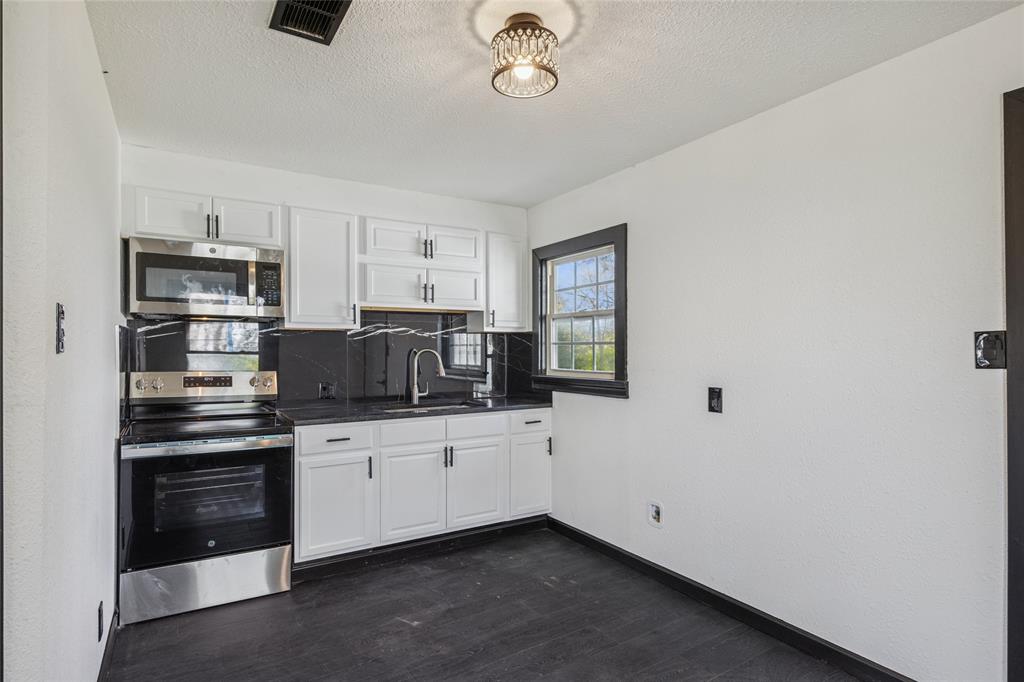 4816 Foard Street Fort Worth, TX 76119 - Photo 14 of 25 a kitchen with stainless steel appliances a sink and a refrigerator