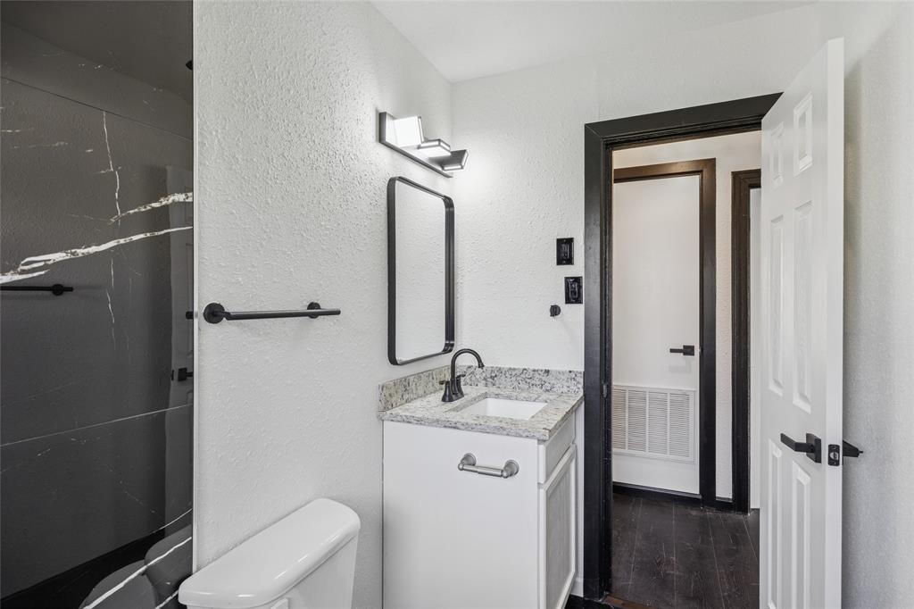 4816 Foard Street Fort Worth, TX 76119 - Photo 20 of 25 a bathroom with a granite countertop sink toilet and shower