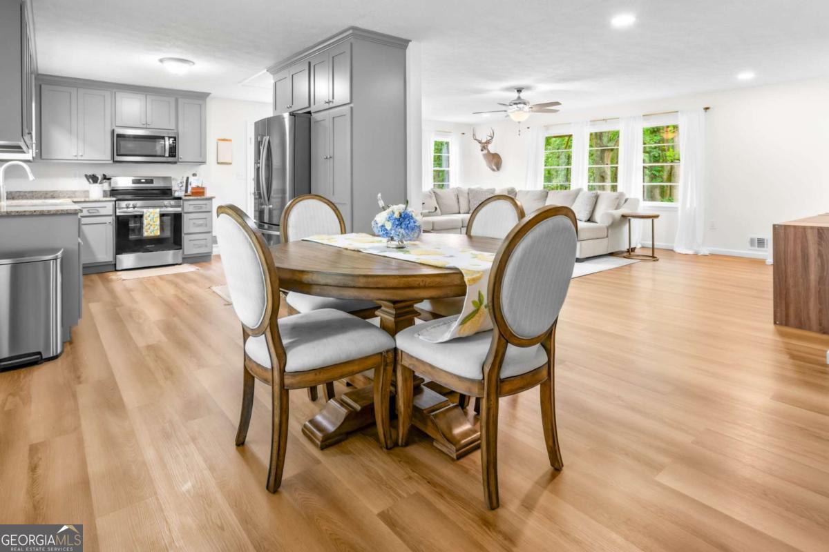 764 Sandy Cross Road Lexington, GA 30648 - Photo 14 of 52 a dining room with furniture a large window and a wooden floor