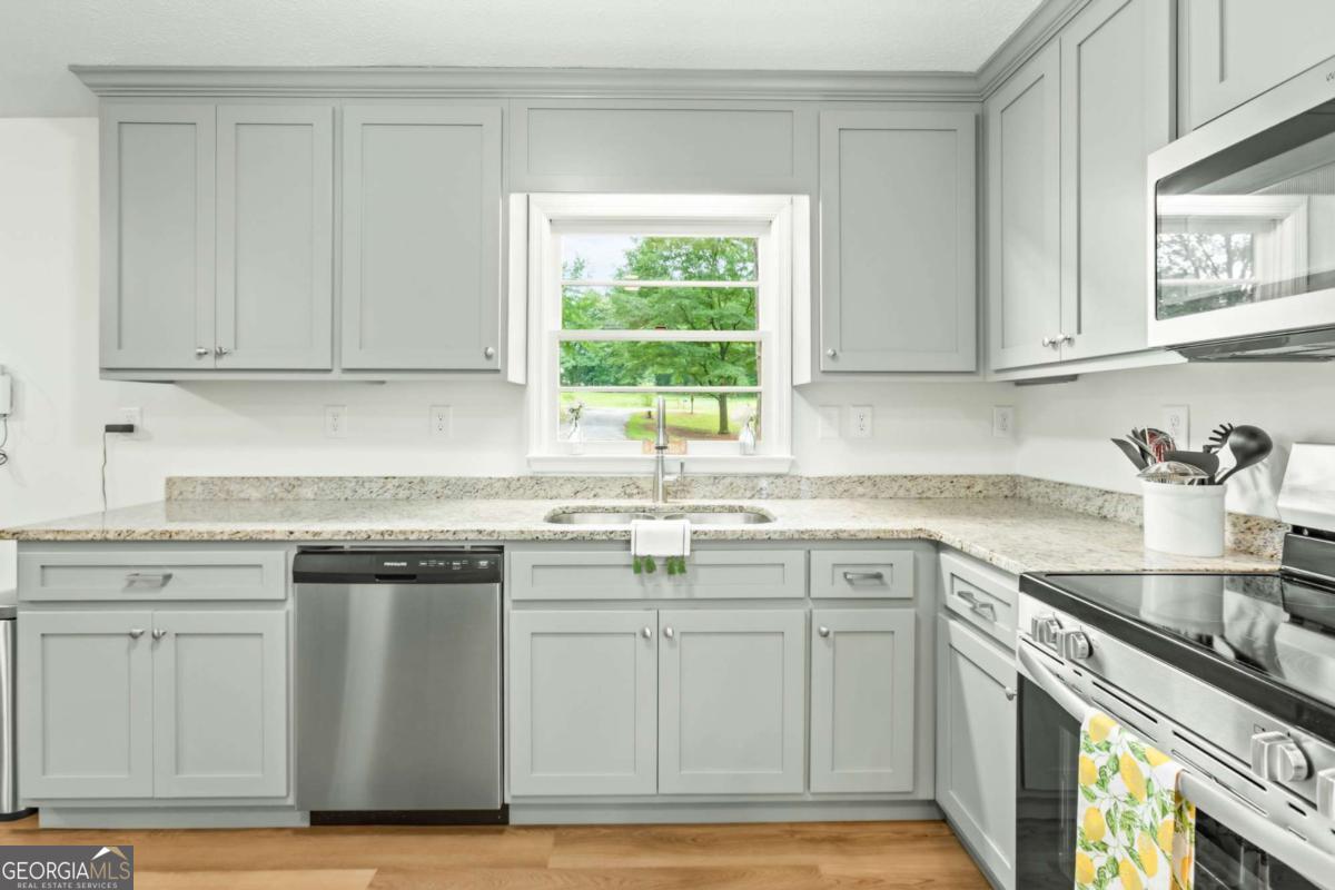 764 Sandy Cross Road Lexington, GA 30648 - Photo 15 of 52 a kitchen with white cabinets appliances and sink