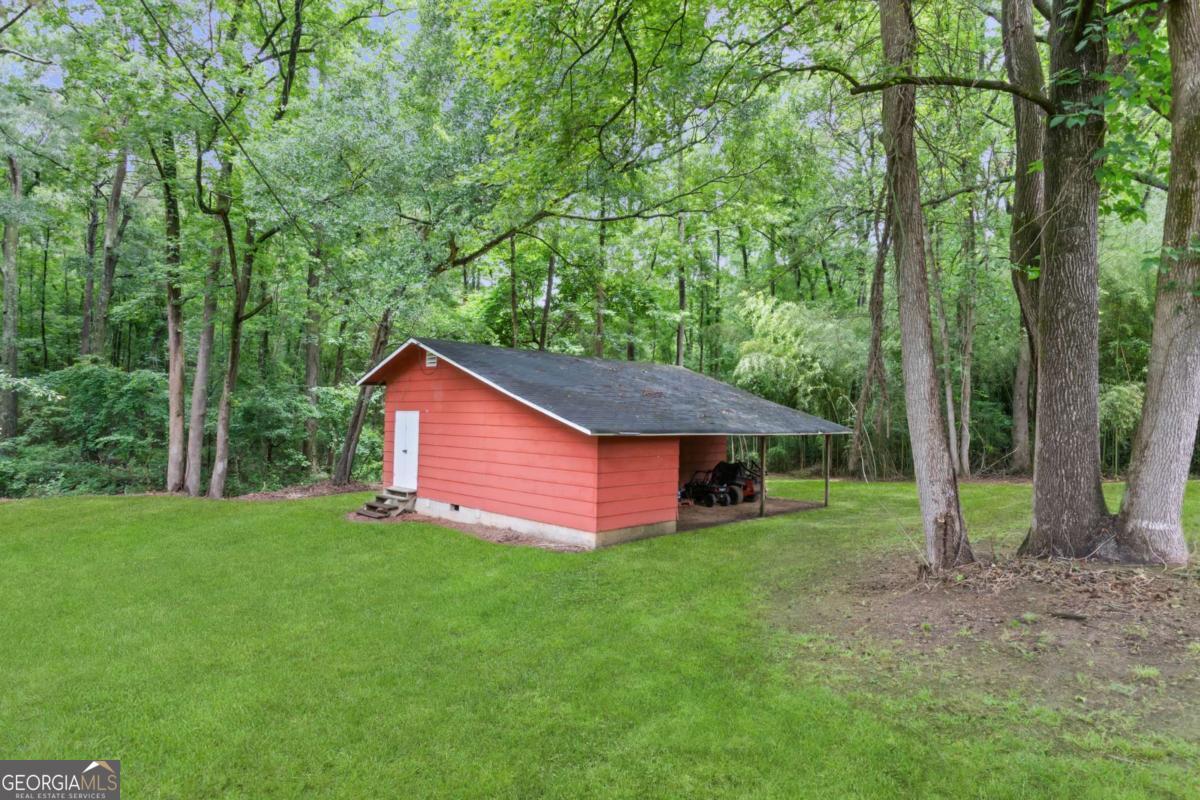 764 Sandy Cross Road Lexington, GA 30648 - Photo 52 of 52 a backyard of a house with plants and large trees