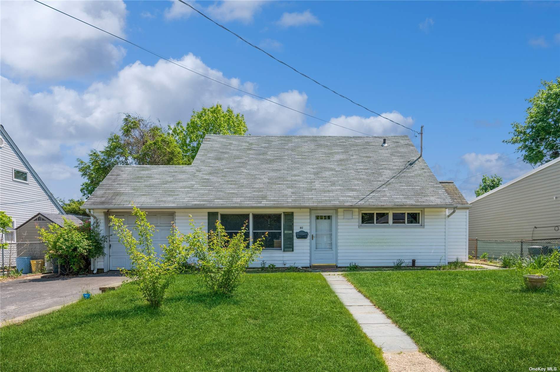 a front view of a house with a garden and plants