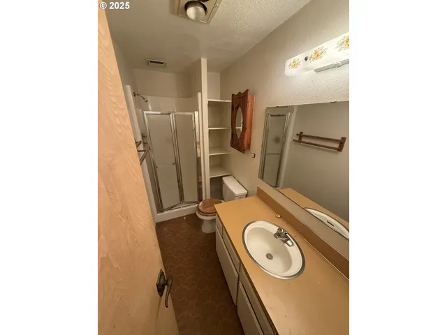 a bathroom with a granite countertop sink and a washing machine