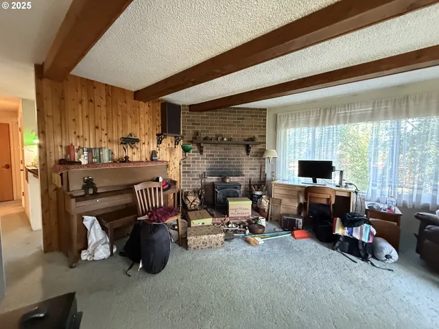 a living room with fireplace furniture and a large window
