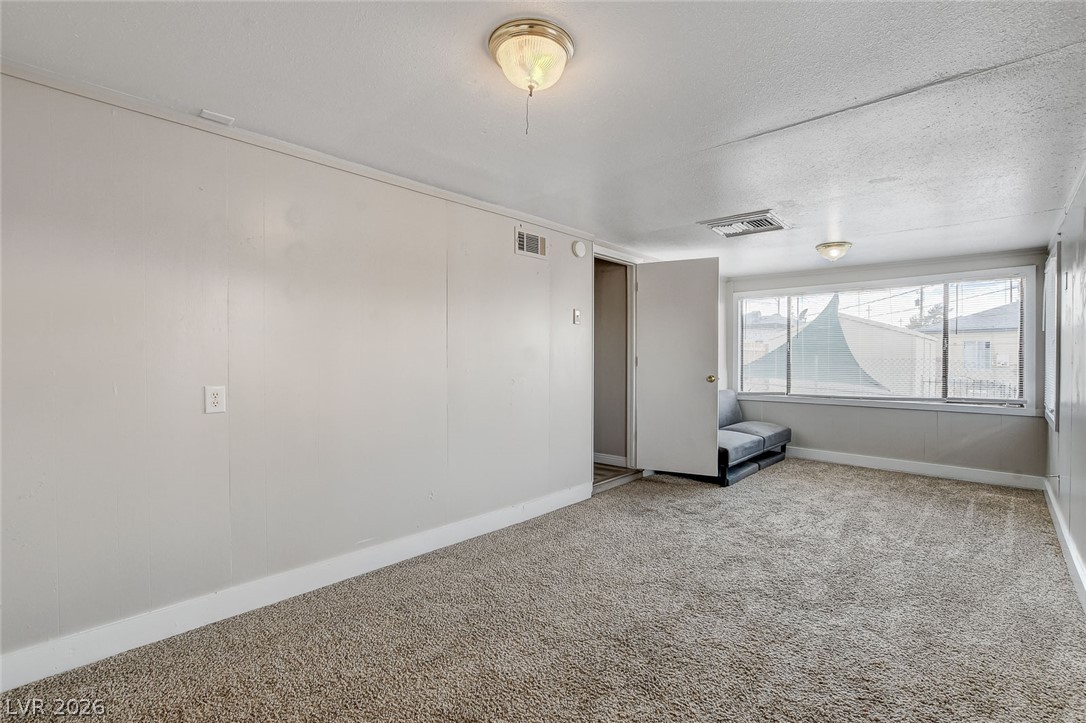 214 West Victory Road Henderson, NV 89015 - Photo 23 of 33 A well-lit room featuring large windows and soft carpeting, creating a neutral canvas for customization.