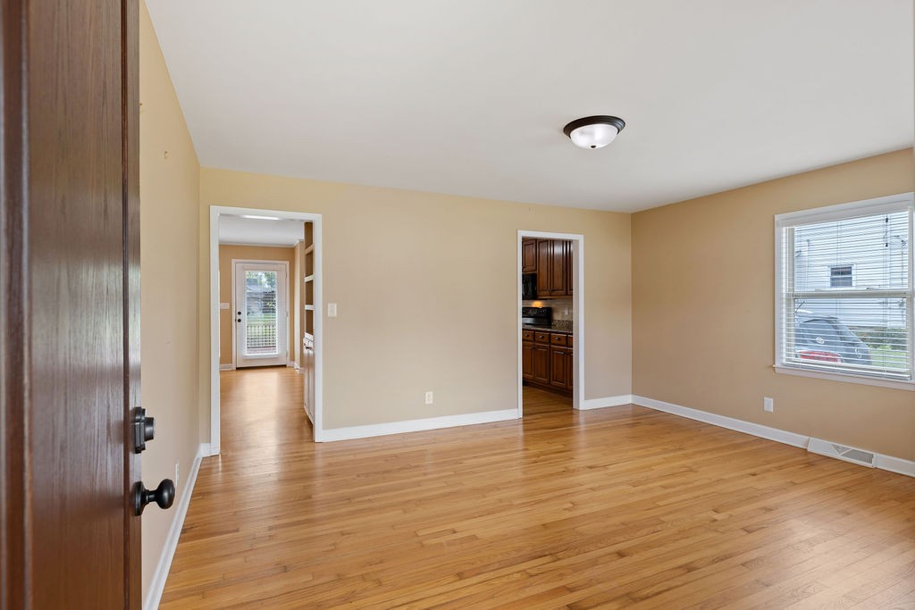 439 East Madison Street Pulaski, TN 38478 - Photo 17 of 36 a view of an empty room with wooden floor and a window