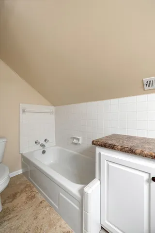 a bathroom with a granite countertop sink and white cabinets