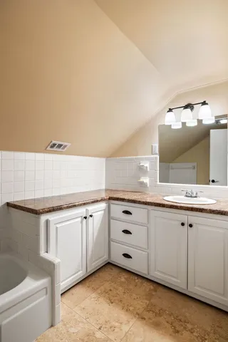 a bathroom with a sink vanity and mirror