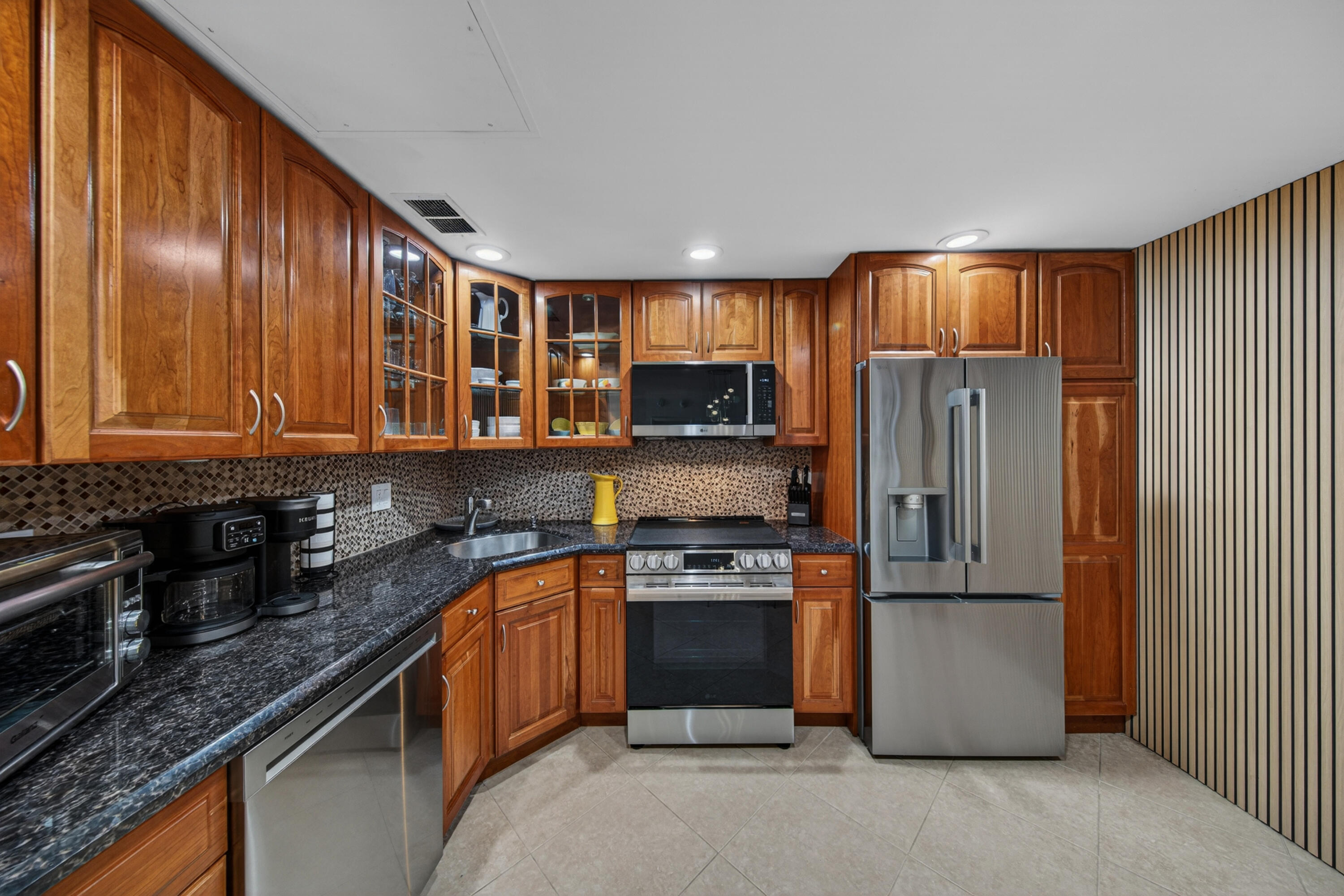 2851 South Ocean Boulevard, Unit 1N Boca Raton, FL 33432 - Photo 5 of 54 a kitchen with stainless steel appliances granite countertop a refrigerator a stove a sink and a microwave