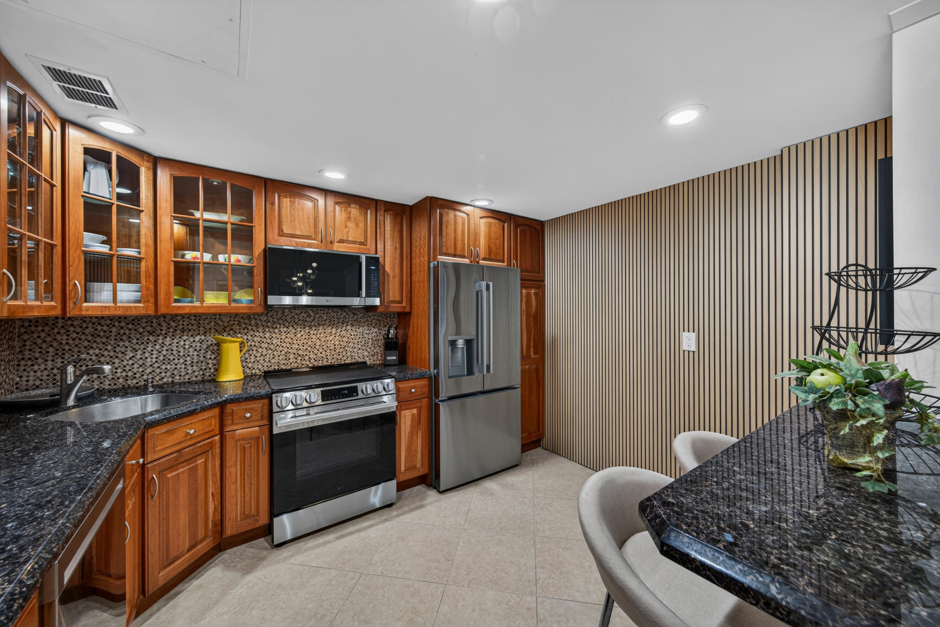 2851 South Ocean Boulevard, Unit 1N Boca Raton, FL 33432 - Photo 6 of 54 a kitchen with stainless steel appliances granite countertop a refrigerator and a sink