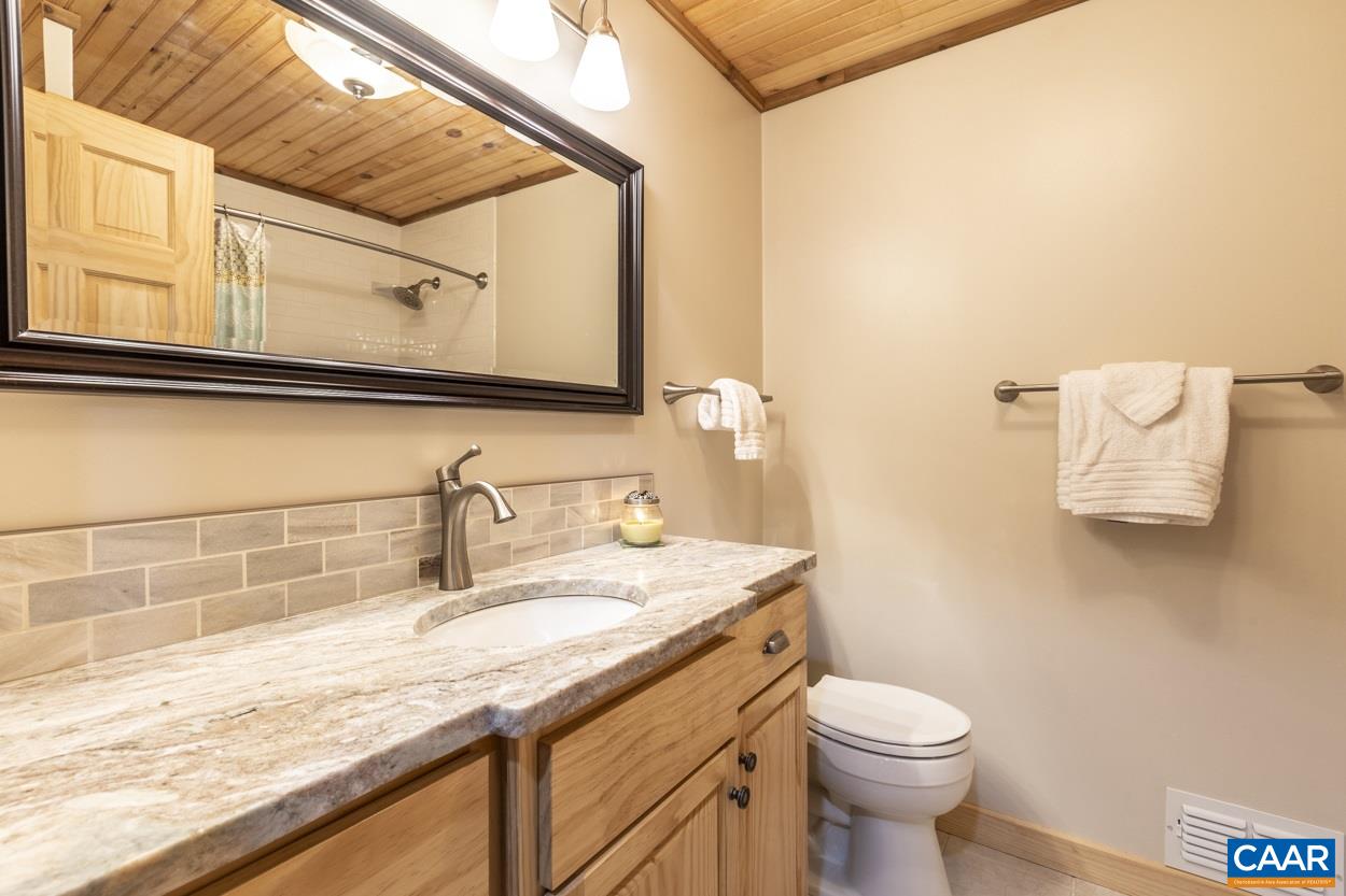 1151 Ridgeview Road Reva, VA 22735 - Photo 33 of 74 a bathroom with a granite countertop sink a toilet and mirror