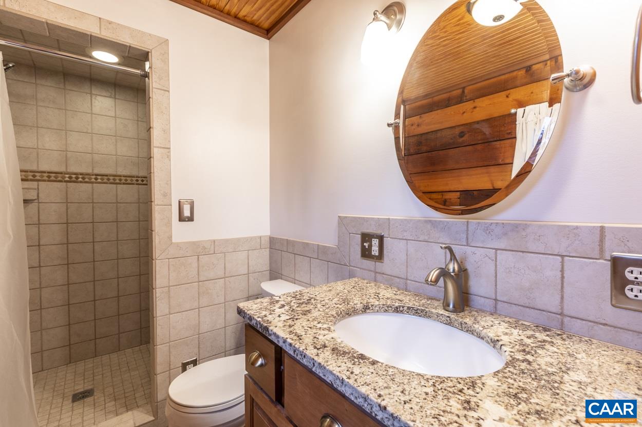 1151 Ridgeview Road Reva, VA 22735 - Photo 41 of 74 a bathroom with a granite countertop sink and a mirror